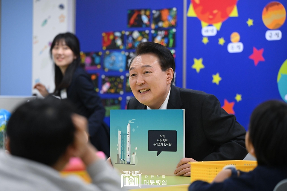 윤석열 대통령이 29일 경기도 화성시 아인초등학교에서 늘봄학교 ‘초1 맞춤형 프로그램’이 진행 중인 교실을 찾아 일일 특별 교사로 학생들에게 우주와 로켓 관련 그림책을 소개하고 있다.