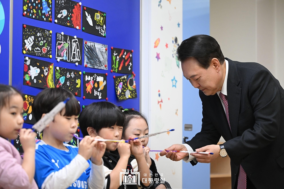 윤석열 대통령이 29일 경기도 화성시 아인초등학교에서 늘봄학교 ‘초1 맞춤형 프로그램’이 진행 중인 교실을 찾아 일일 특별 교사로 학생들과 수업하며 학생들의 누리호 로켓 모형 발사를 돕고 있다. 