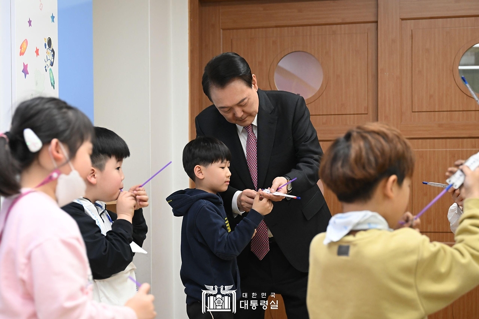 윤석열 대통령이 29일 경기도 화성시 아인초등학교에서 늘봄학교 ‘초1 맞춤형 프로그램’이 진행 중인 교실을 찾아 일일 특별 교사로 학생들과 수업하며 학생들의 누리호 로켓 모형 발사를 돕고 있다. 