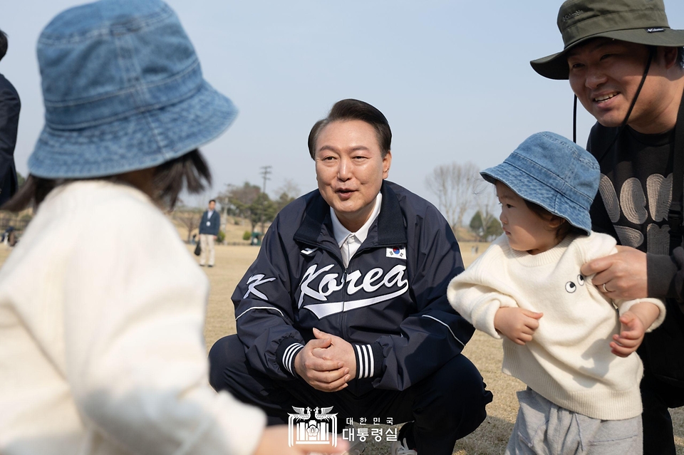 윤석열 대통령이 6일 서울 용산어린이정원 잔디마당을 찾아 한 가족과 대화하고 있다. 