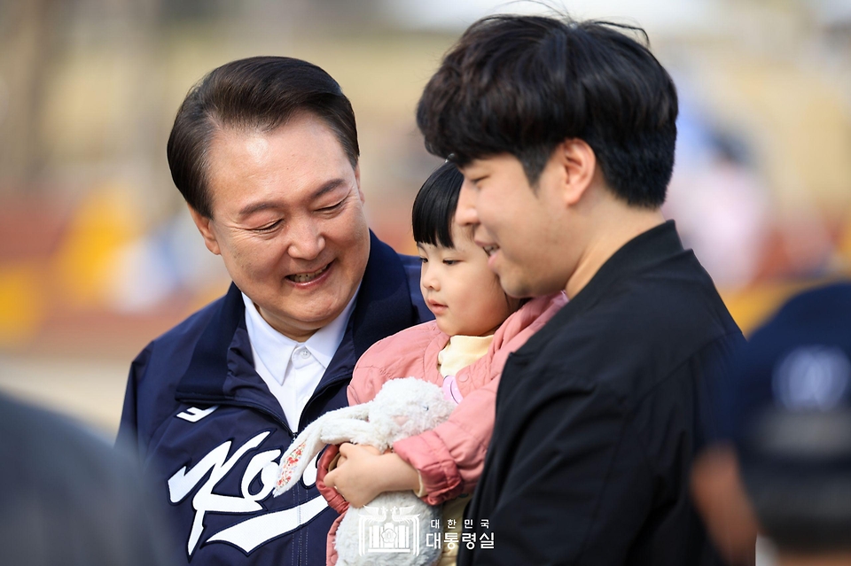 윤석열 대통령이 6일 서울 용산어린이정원 내 분수 정원을 찾은 가족과 기념 사진을 찍고 있다. 