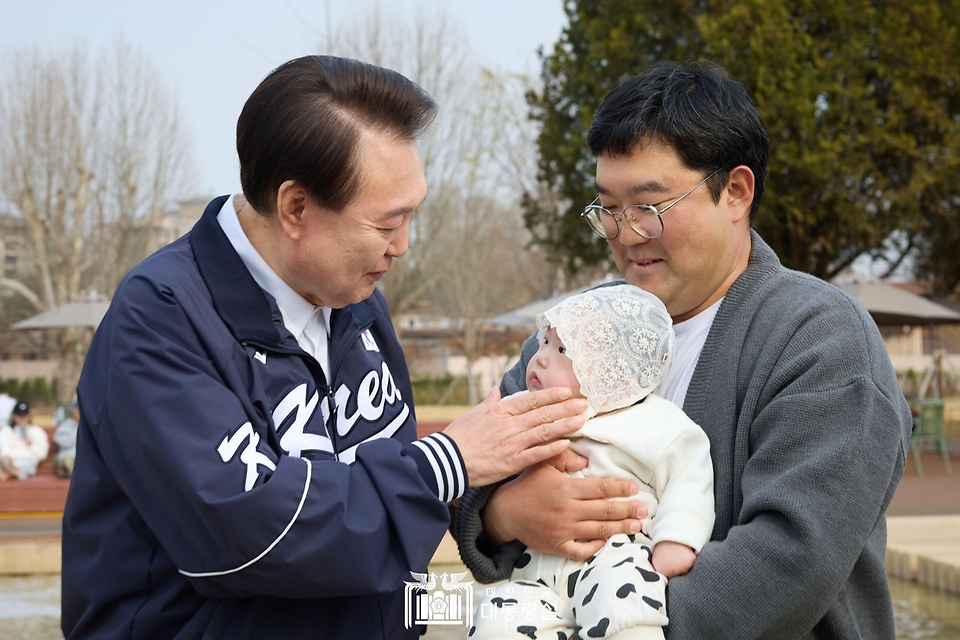 윤석열 대통령이 6일 서울 용산어린이정원 내 분수 정원을 찾은 가족과 인사하고 있다.