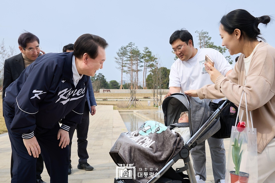 윤석열 대통령이 6일 서울 용산어린이정원 내 분수 정원을 찾은 가족과 인사하고 있다. 