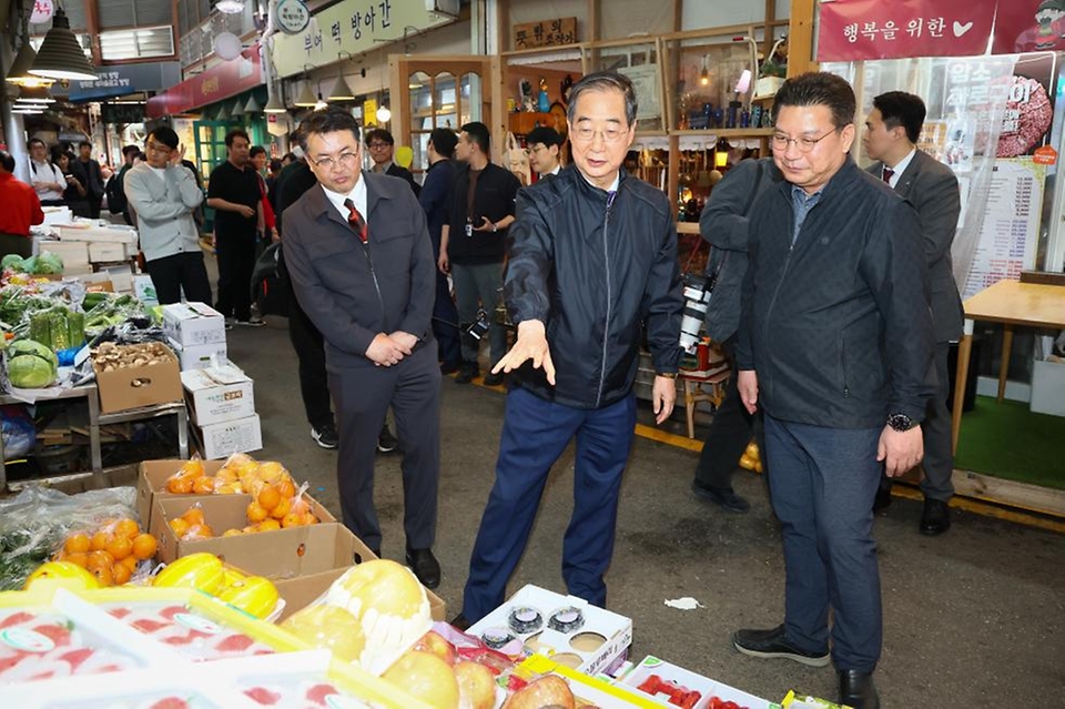 한덕수 국무총리가 20일 서울 종로구 통인시장을 방문해 점포를 돌아보며 상인들과 대화를 나누고 있다.