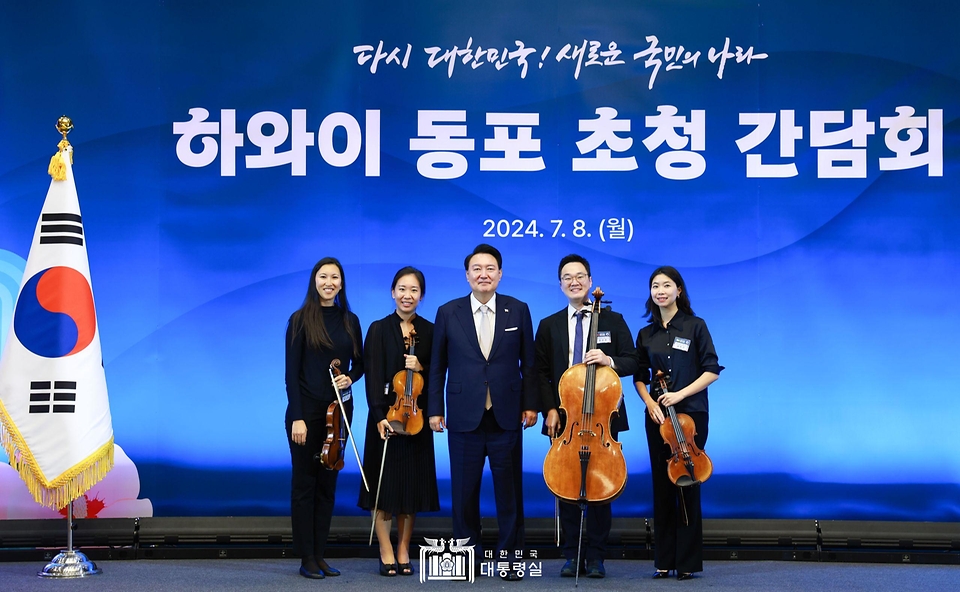 윤석열 대통령이 8일(현지시간) 미국 하와이 호놀룰루 쉐라톤 와이키키 호텔에서 열린 동포 초청 간담회에서 하와이 심포니 오케스트라 현악 4중주 문화 공연를 관람한 뒤 공연 참가자들과 기념 촬영을 하고 있다. 