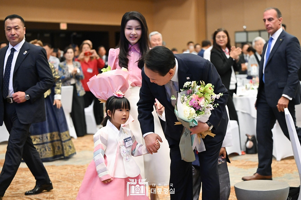 윤석열 대통령과 김건희 여사가 8일(현지시간) 미국 하와이 호놀룰루 쉐라톤 와이키키 호텔에서 열린 동포 초청 간담회에서 화동과 함께 입장하고 있다. 