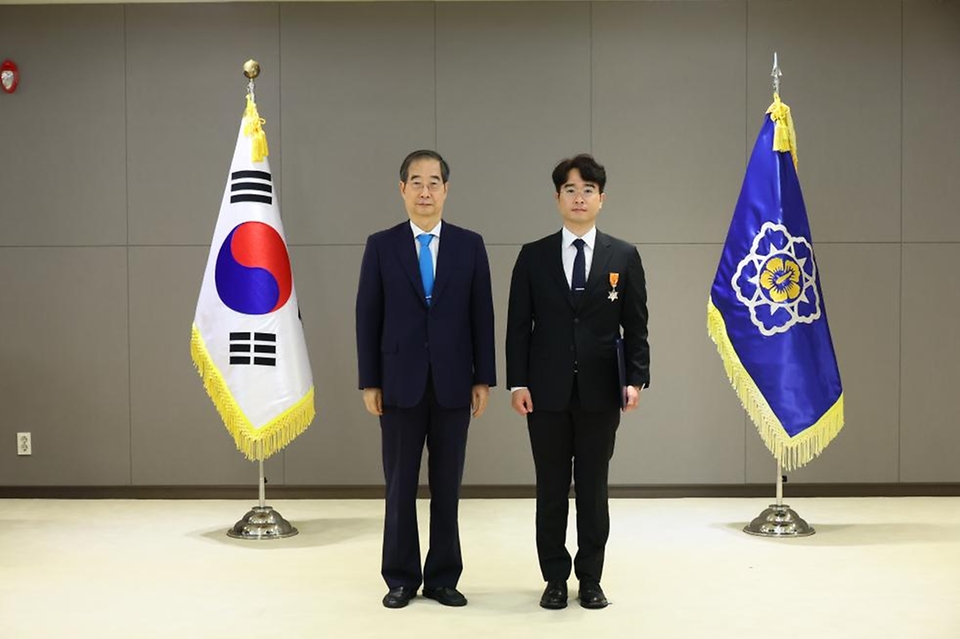 한덕수 국무총리가 18일 정부세종청사 의전행사실에서 열린 ‘제4회 적극행정 유공자 포상식’에서 민원 발생지역의 악취 측정방안 마련 및 해당 기업이 폐수처리장을 개선하도록 설득한 공로로 최민욱 수원시 지방환경주사에게 근정포장을 수여한 뒤 기념 촬영을 하고 있다.