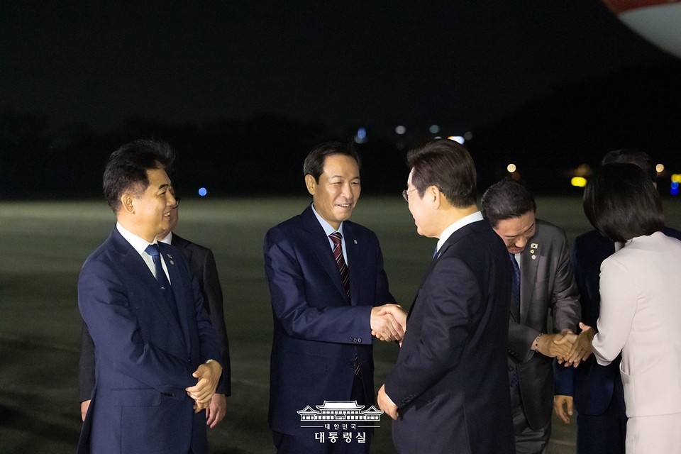 이재명 대통령과 김혜경 여사가 28일 일본·미국 순방 일정을 마치고 경기도 성남 서울공항에 도착해 우상호 정무수석과 인사하고 있다.