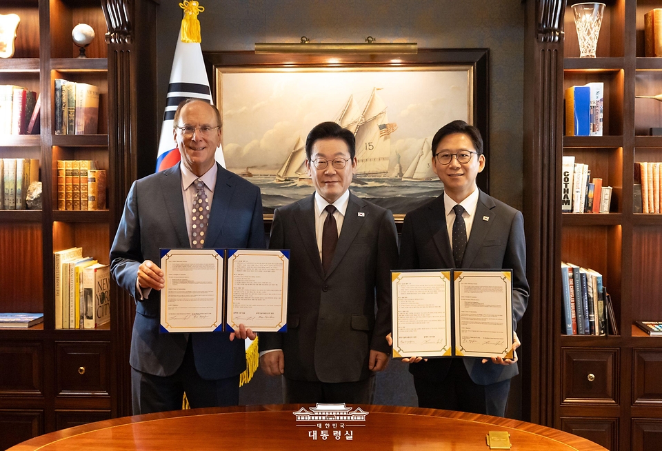 이재명 대통령이 22일(현지 시간) 미국 뉴욕의 한 호텔에서 배경훈 과학기술정보통신부 장관과 세계경제포럼 의장인 래리 핑크 블랙록 회장의 AI 산업 글로벌 협력을 위한 MOU 체결 때 함께 기념 촬영을 하고 있다.