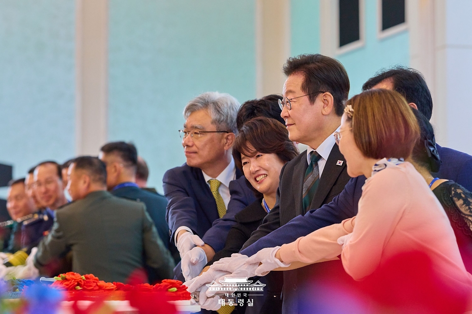이재명 대통령이 1일 충남 계룡대에서 열린 건군 77주년 국군의 날 기념 오찬에서 참석자들과 축하 떡을 자르고 있다.