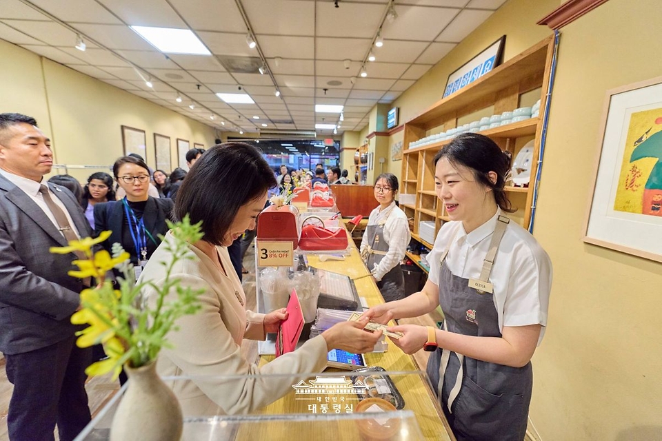 김혜경 여사가 23일(현지시간) 미국 뉴욕 코리아타운 한 식당을 방문해 김밥을 구입하고 있다.