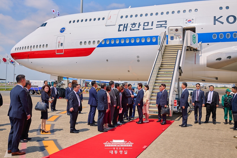 이재명 대통령과 김혜경 여사가 23일(현지시간) 일본 도쿄 하네다 국제공항에서 영접 관계자들과 인사하고 있다. 
