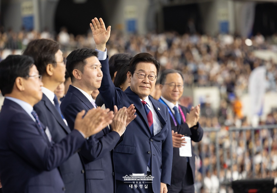 이재명 대통령이 17일 부산아시아드주경기장에서 열린 제106회 전국체육대회 개막식에서 선수단 입장을 지켜보며 인사하고 있다.