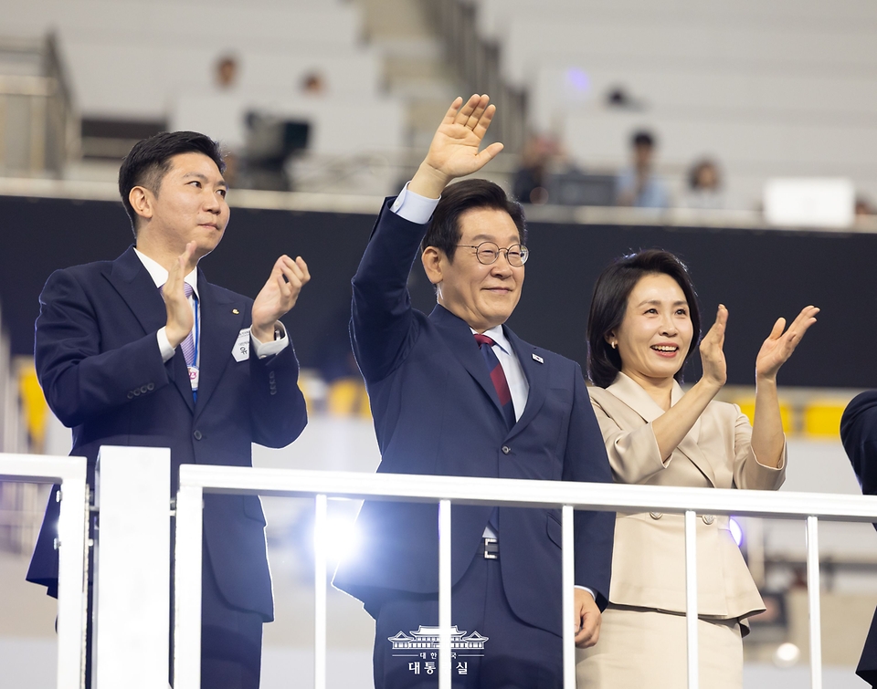 이재명 대통령과 김혜경 여사가 17일 부산아시아드주경기장에서 열린 제106회 전국체육대회 개막식에서 선수단 입장을 지켜보며 인사하고 있다.