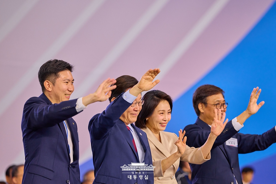 이재명 대통령과 김혜경 여사가 17일 부산아시아드주경기장에서 열린 제106회 전국체육대회 개막식에서 선수단 입장을 지켜보며 인사하고 있다.