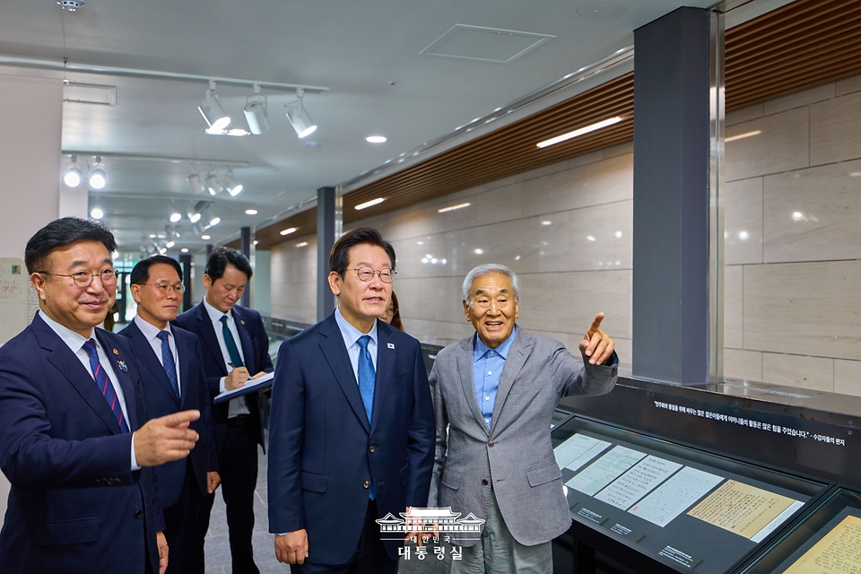 이재명 대통령이 21일 서울 용산구 민주화운동기념관을 찾아 이재오 민주화운동기념사업회 이사장의 설명을 듣고 있다.