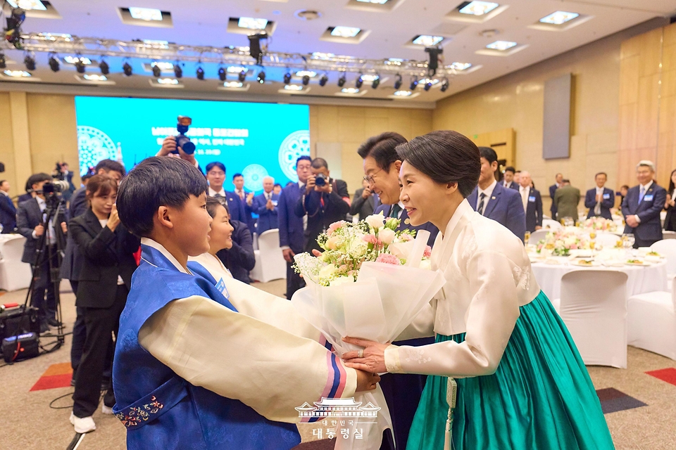 이재명 대통령과 김혜경 여사가 23일(현지 시간) 남아프리카공화국 요하네스버그 한 호텔에서 열린 동포 오찬 간담회에서 화동들에게 꽃다발을 받고 있다.