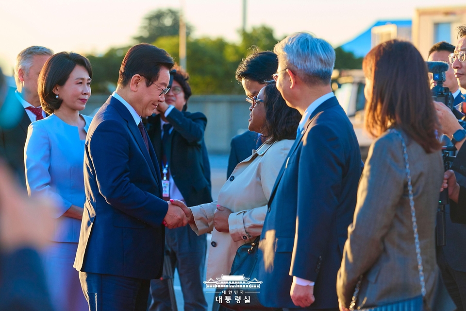 이재명 대통령이 23일(현지 시간) 남아프리카공화국 요하네스버그 국제공항에서 G20 정상회의 참석을 마치고 튀르키예 앙카라로 출발하기 전 환송인사와 악수하고 있다.