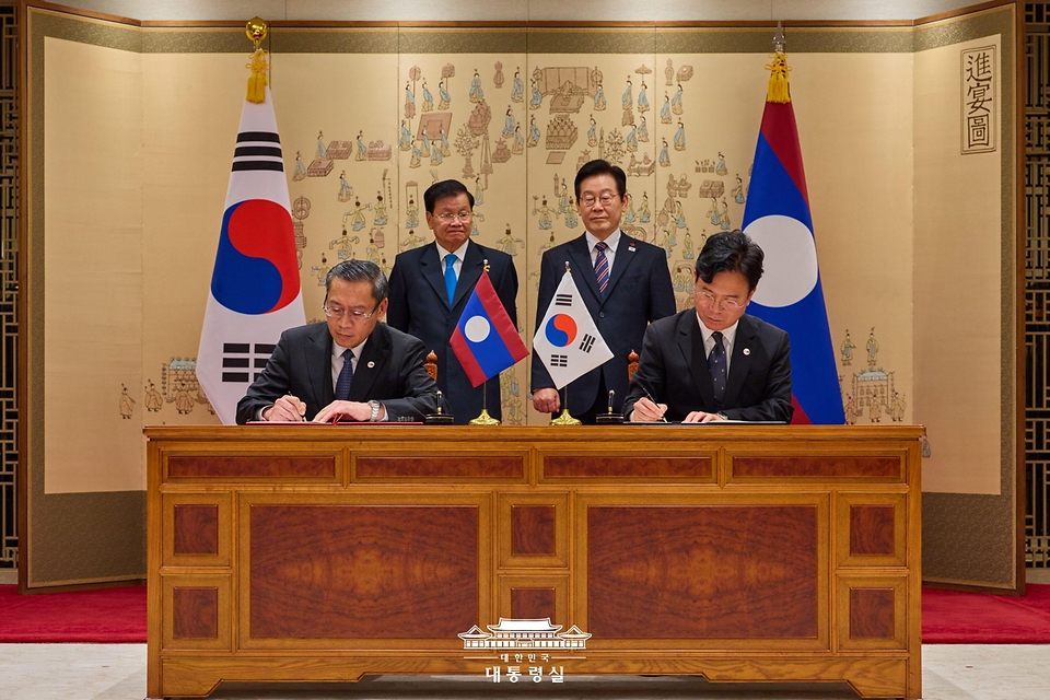 김영훈 노동부 장관과 포싸이 싸이냐선 라오스 노동사회복지부 장관이 15일 용산 대통령실에서 이재명 대통령과 통룬 시술릿 라오스 국가주석이 임석한 가운데 고용허가제 인력송출에 관한 양해각서에 서명하고 있다.