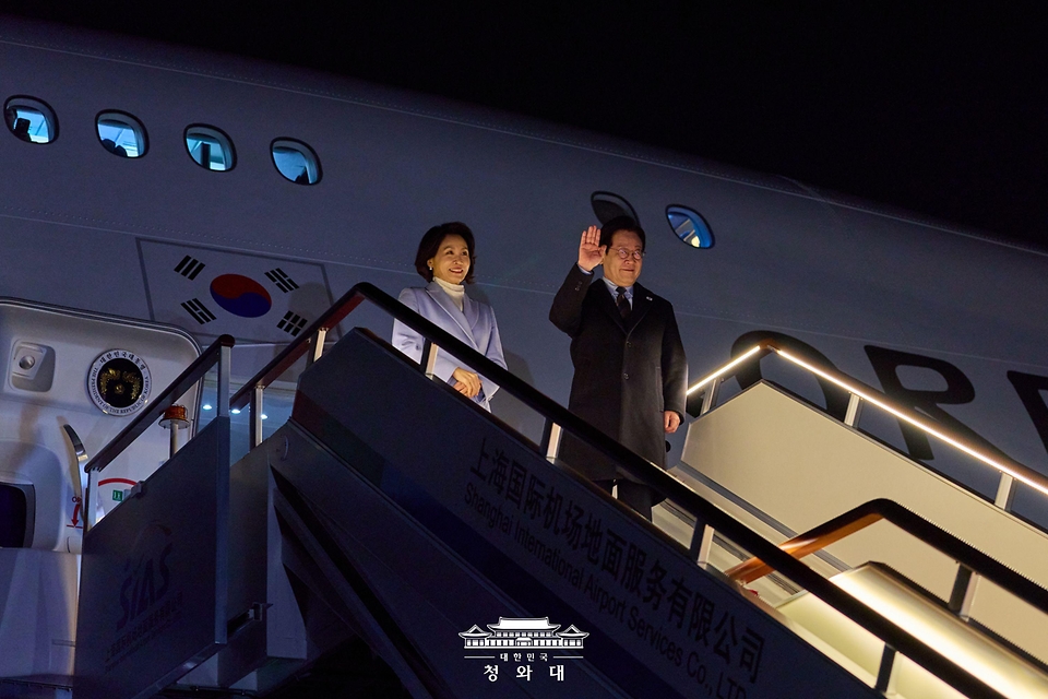중국 국빈 방문 공식 일정을 마친 이재명 대통령과 김혜경 여사가 1월 7일(현지 시간) 중국 상하이 푸동 국제공항에서 공군 1호기에 올라 인사하고 있다.
