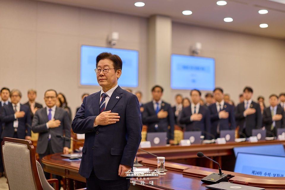이재명 대통령이 2월 19일 청와대에서 열린 수석보좌관회의에서 국기에 경례하고 있다.
