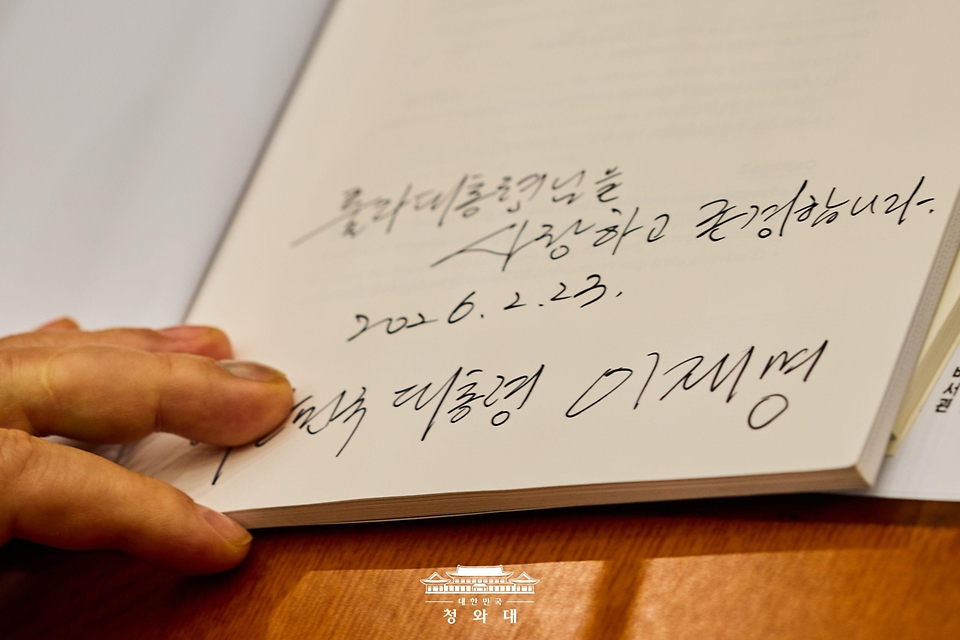 이재명 대통령이 2월 23일 청와대에서 정상회담에 앞서 브라질 루이스 이나시우 룰라 다 시우바 대통령에게 건네받은 책에 서명하고 있다. 