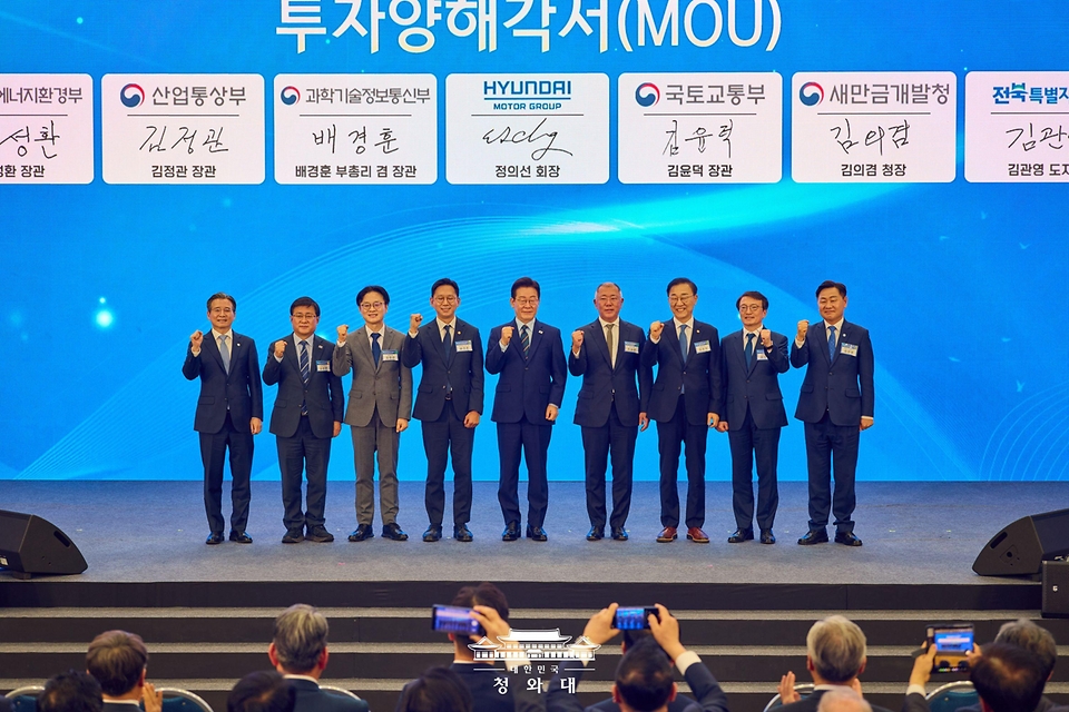 이재명 대통령과 정의선 현대자동차 회장이 2월 27일 전북 군산시 새만금 컨벤션센터에서 열린 새만금 로봇·수소·AI 시티 투자협약식에서 투자협약을 체결한 뒤 기념촬영을 하고 있다. (왼쪽부터 김용범 정책실장, 김성환 기후에너지환경부 장관, 김정관 산업통상부 장관, 배경훈 부총리 겸 과학기술정보통신부 장관, 이재명 대통령, 정의선 현대자동차 회장, 김윤덕 국토교통부 장관, 김의겸 새만금청장, 김관영 전북도지사.)