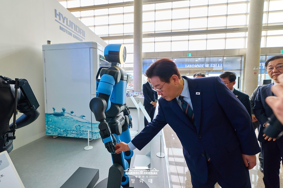이재명 대통령이 2월 27일 전북 군산시 새만금 컨벤션센터에서 열린 새만금 로봇·수소·AI 시티 투자협약식에서 아틀라스를 살펴보고 있다.