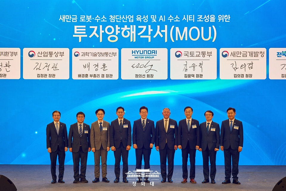 이재명 대통령과 정의선 현대자동차 회장이 2월 27일 전북 군산시 새만금 컨벤션센터에서 열린 새만금 로봇·수소·AI 시티 투자협약식에서 투자협약을 체결한 뒤 기념촬영을 하고 있다. (왼쪽부터 김용범 정책실장, 김성환 기후에너지환경부 장관, 김정관 산업통상부 장관, 배경훈 부총리 겸 과학기술정보통신부 장관, 이재명 대통령, 정의선 현대자동차 회장, 김윤덕 국토교통부 장관, 김의겸 새만금청장, 김관영 전북도지사.)