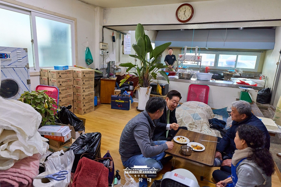 이재명 대통령이 3월 13일 충북 청주시 서원구 사창시장을 찾아 한 상점에서 음식을 맛보고 상인과 대화하고 있다.