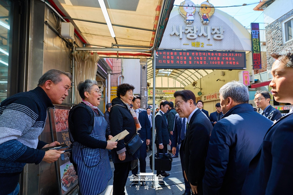 이재명 대통령이 3월 13일 충북 청주시 서원구 사창시장을 찾아 상인과 인사를 하고 있다.