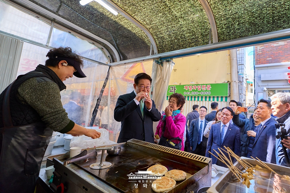 이재명 대통령이 3월 13일 충북 청주시 서원구 사창시장을 찾아 한 상점에서 음식을 맛보고 있다.