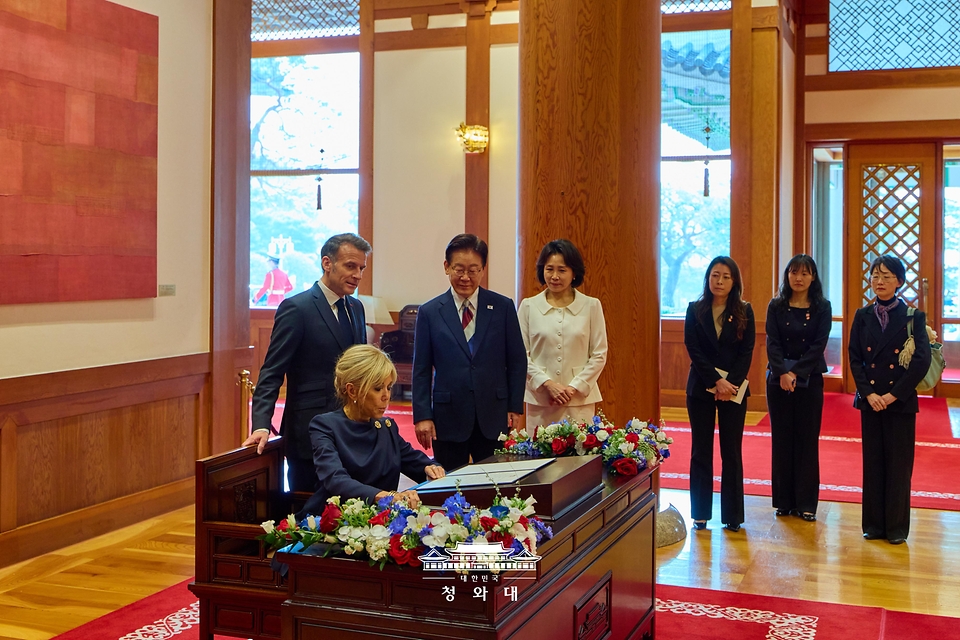 이재명 대통령과 김혜경 여사가 4월 3일 청와대에서 에마뉘엘 마크롱 프랑스 대통령에 이어 방명록을 작성하는 브리지트 마크롱 여사를 지켜보고 있다.