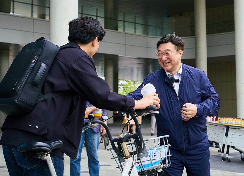 윤호중 행정안전부 장관이 4월 22일 정부세종청사에서 '자전거의 날'을 맞아 세종시 공영 자전거 등을 이용해 출근하는 직원들에게 음료를 나눠주며 격려하고 있다.