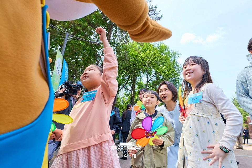김혜경 여사가 4월 29일 서울 어린이대공원에서 열린 당원병 환아의 건강한 식생활을 위한 희망쿠키 굽기 행사에서 참석한 아이들과 산책을 하고 있다.