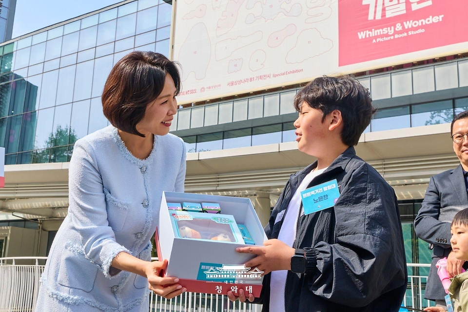 김혜경 여사가 4월 29일 서울 어린이대공원에서 열린 당원병 환아의 건강한 식생활을 위한 희망쿠키 굽기 행사에서 기념품을 전달하고 있다.