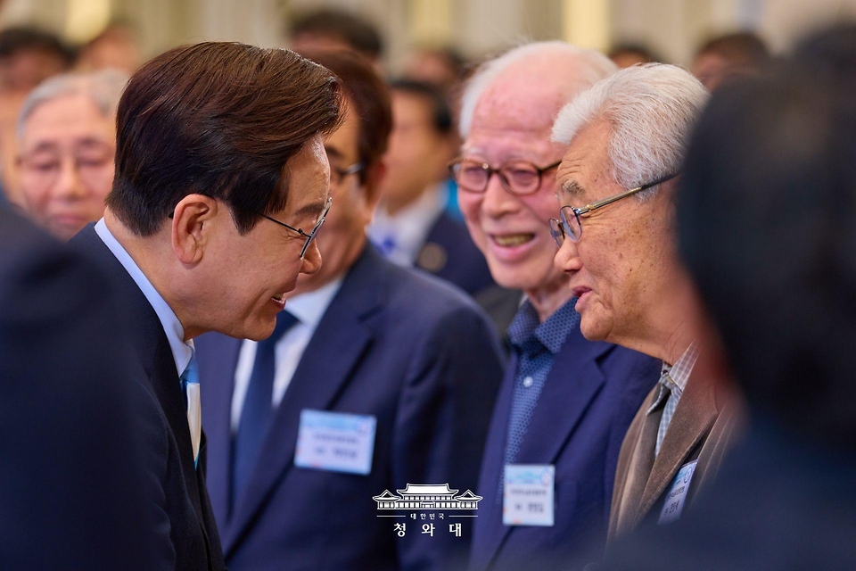 이재명 대통령이 5월 1일 청와대 영빈관에서 열린 노동절 기념식에 입장하며 천영세 민주노총 지도위원과 인사하고 있다.