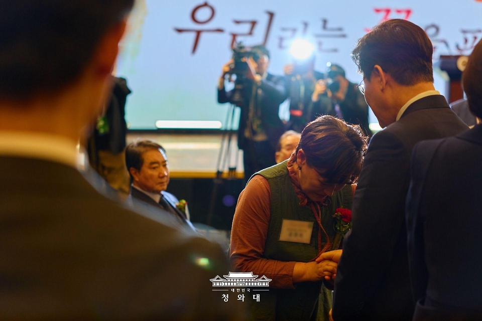 이재명 대통령이 5월 8일 서울 중구 대한상공회의소에서 열린 어버이날 기념식에서 순직 소방관, 경찰관 부모님들에게 카네이션을 달아드린 후 한 유가족을 위로하고 있다.