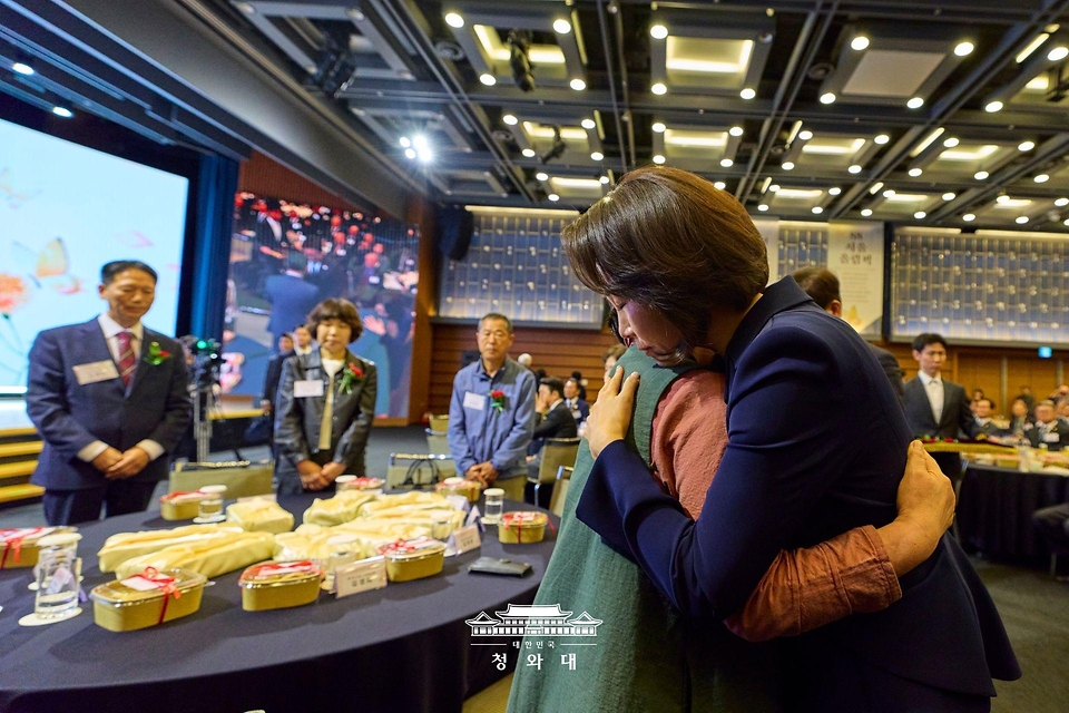 김혜경 여사가 5월 8일 서울 중구 대한상공회의소에서 열린 어버이날 기념식에서 순직 소방관, 경찰관 부모님들에게 카네이션을 달아드린 후 한 유가족을 위로하고 있다.