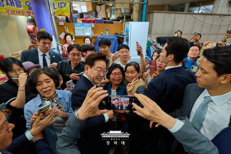 이재명 대통령이 5월 13일 울산 남목마성시장을 방문해 시민 및 상인들과 기념촬영을 하고 있다.