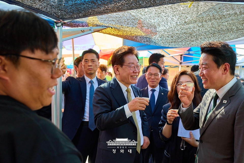 이재명 대통령이 5월 14일 성남 모란시장에서 강훈식 비서실장과 시식을 하며 대화하고 있다.