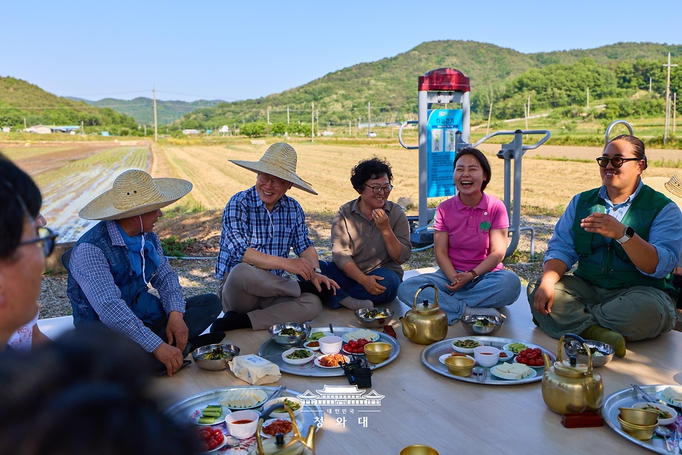 이재명 대통령이 5월 15일 대구 군위군 소보면에서 모내기 체험을 마친 뒤 주민들과 새참을 먹고 있다.