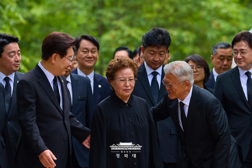 이재명 대통령이 지난 5월 23일 경남 김해 봉하마을 고 노무현 전 대통령 사저 인근에서 권양숙 여사, 문재인 전 대통령과 대화하며 이동하고 있다.