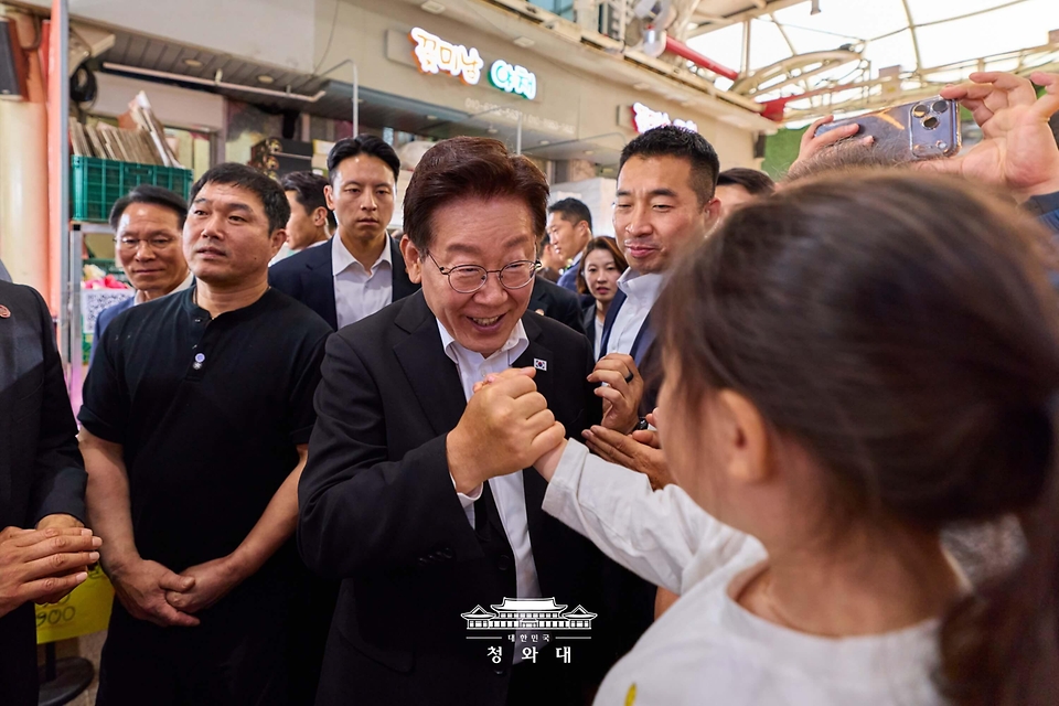 이재명 대통령이 5월 23일 경남 김해 외동전통시장을 방문해 한 어린이와 인사하고 있다.