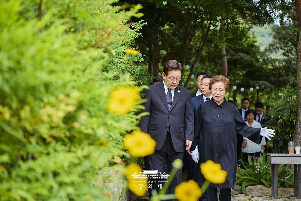 이재명 대통령과 권양숙 여사가 5월 23일 경남 김해 봉하마을 고 노무현 전 대통령 사저 인근에서 대화하며 이동하고 있다.