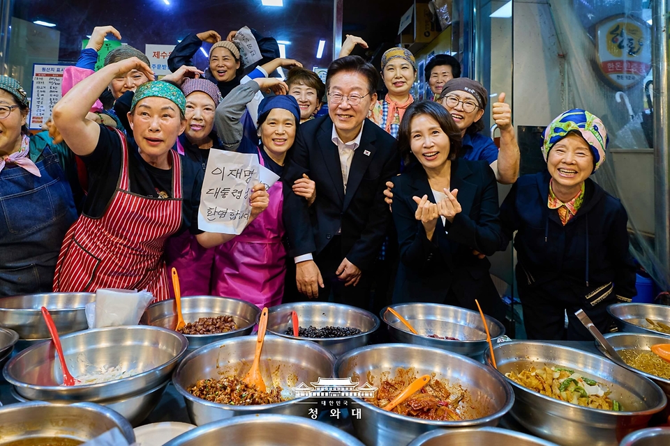이재명 대통령과 김혜경 여사가 5월 23일 경남 김해 외동전통시장을 방문해 상인 및 시민들과 기념촬영을 하고 있다.
