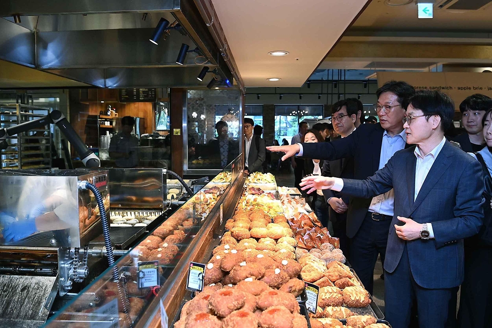 김정관 산업통상부 장관이 5월 27일 대전 서구 롯대백화점문화센터에서 한국로봇산업진흥원, 성심당(로쏘), 로이랩스, 인터텍을 비롯한 관련 유관기관 및 실증 참여기업 대표 등 관계자가 참석한 가운데 열린 '국민체감 제조 AI 현장 확산 간담회'를 주재했다.<br>
<br>
또한 간담회에 앞서 성심당 롯데백화점 대전점을 방문해 튀김소보로 생산과정에 AI를 적용하는 AI팩토리 실증 현장을 점검하고, AI 공급기업과 함께 M.AX 확산 방안 등을 논의하고 있다.