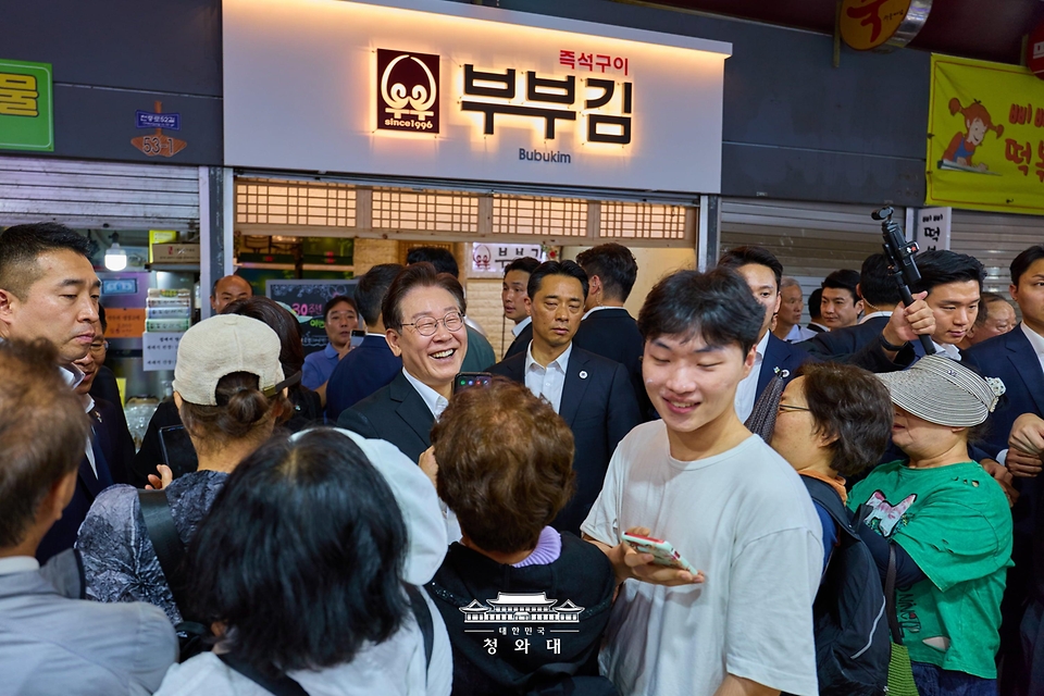 이재명 대통령과 김혜경 여사가 6월 6일 서울 강동구 중앙보훈병원 위문 방문 후 인근 길동복조리시장에서 시민들과 대화하고 있다.