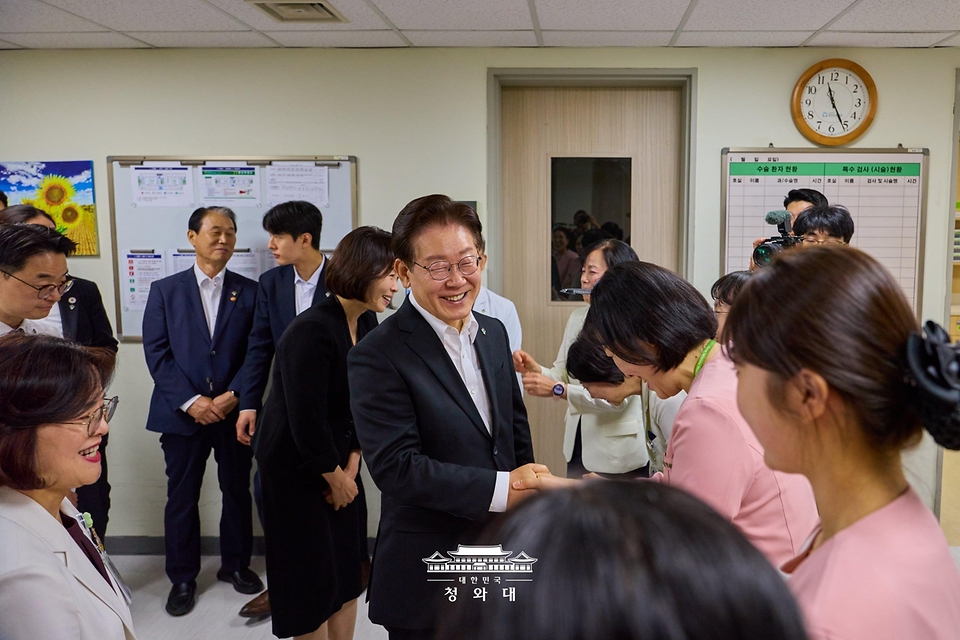 이재명 대통령이 현충일인 6월 6일 서울 강동구 중앙보훈병원에서 의료진과 인사하고 있다.
