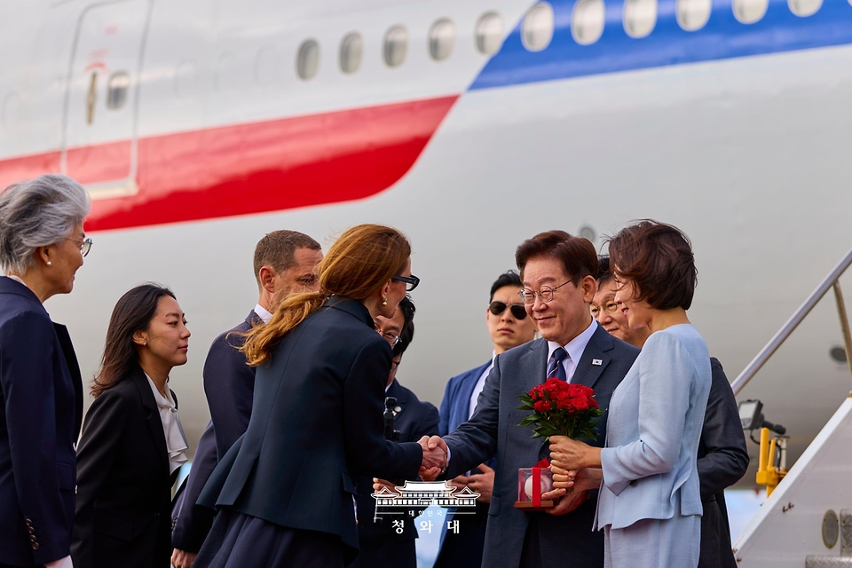 이재명 대통령이 7월 24일(현지 시간) 샌프란시스코 국제공항에서 영접 나온 다니엘 루리 시장으로부터 샌프란시스코 자이언츠의 이정후 사인볼을 선물 받은 뒤 이야기를 나누고 있다. 